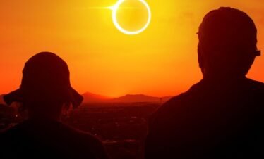Total solar eclipse over the Egyptian desert landscape with a glowing ring of fire